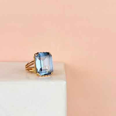 a close up of a ring with a blue topaz stone