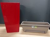 a red container sitting next to a gray container on a table