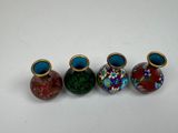 three small vases are lined up in a row on a white surface