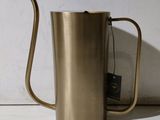 a metal coffee pot with a tea bag in it