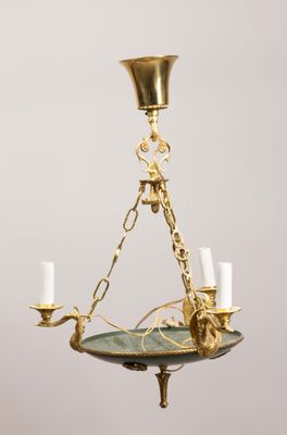 un lustre ancien en laiton avec trois bougies suspendu au plafond