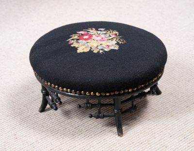 un petit tabouret noir orné d'un motif floral