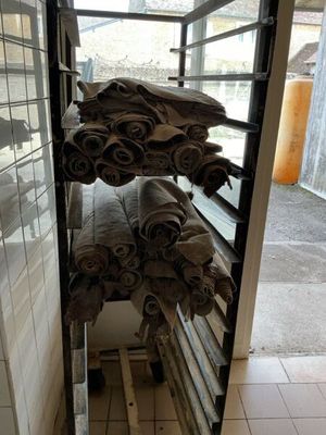 several rolls of towels stacked on a rack in a room