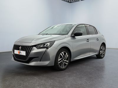 La voiture argentée est garée dans une pièce blanche au sol noir.