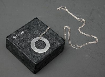 une petite boîte posée sur une table, sur laquelle est posé un collier