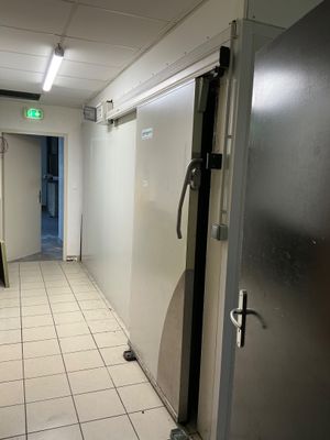 a white tiled floor in a room with a refrigerator and a door