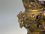 an old brass vase with a handle and a handle on a stand