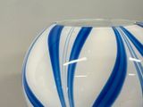 a blue and white striped vase sitting on a table