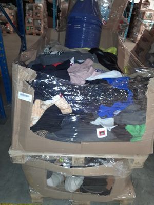 un tas de vêtements dans un carton, dans un entrepôt