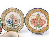 three plates and a cup sitting next to each other on a white surface