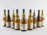six bottles of wine lined up in a row on a white surface