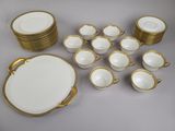un assortiment d'assiettes, de tasses et de soucoupes en porcelaine blanche et dorée