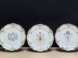six assiettes aux motifs variés sont alignées sur une table