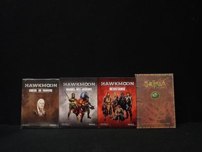 trois livres sont posés sur une surface noire, sur fond noir