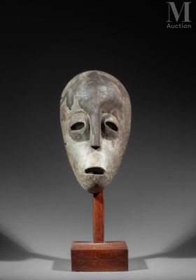 a close up of a mask on a wooden stand