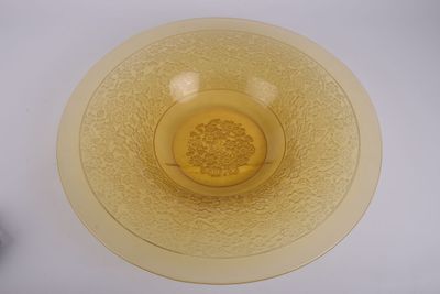 un bol jaune posé sur une table blanche