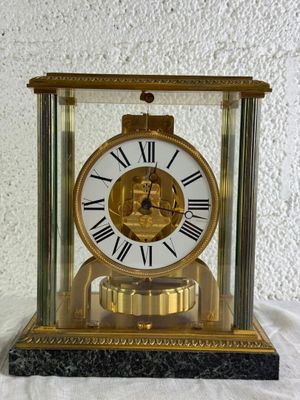 une horloge dorée ornée de chiffres romains, posée sur une table