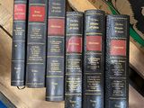 four books are stacked on top of each other on a wooden crate