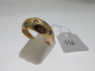 gros plan d'une bague en or sur une surface blanche avec une étiquette de prix
