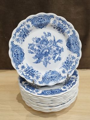 des assiettes bleues et blanches empilées les unes sur les autres sur une table en bois