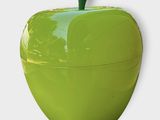 une pomme verte posée sur une surface blanche