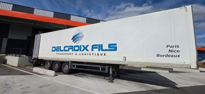 the truck is parked in front of a building with a blue sky in the background