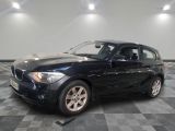 une photo d'une BMW noire sur un sol à damier
