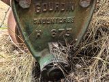 a rusted out machine sitting in the grass