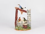 a ceramic figurine of a bird on a well
