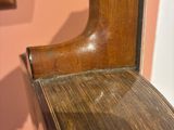 a close up of a wooden bench with a mirror in the background