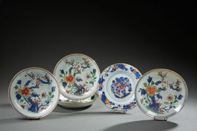 four plates with flowers and birds on them are sitting on a table
