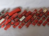 a lot of red toy trucks on a white surface