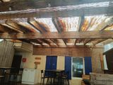 a room that has a wooden ceiling and a table and chairs
