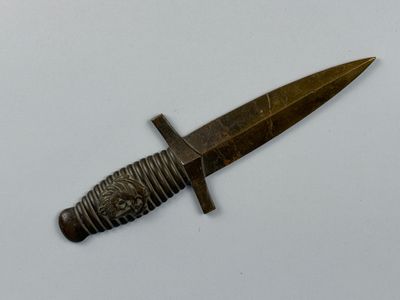 un petit couteau posé sur une surface blanche