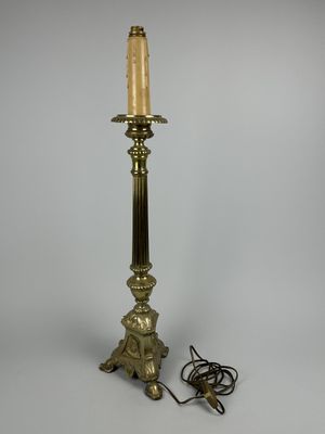 une lampe de table ancienne en laiton surmontée d'une bougie