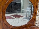 a mirror that is sitting on top of a wooden cabinet