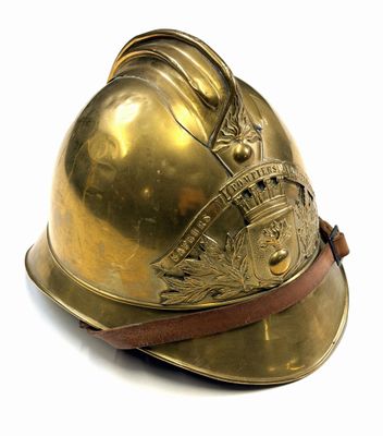 brass fireman ' s helmet on a white background with a leather strap