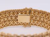gold bracelet with a square clasp in the middle of it