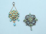 two small pendants with turquoise and green beads on a white surface