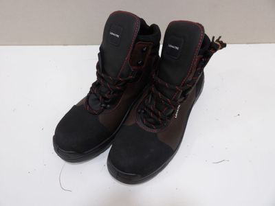 la paire de bottes noires repose sur une surface blanche