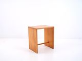 a small wooden stool on a white surface