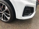 a close up of a white car parked in a parking lot