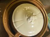 a white bowl with a lion head on it sitting on top of a table