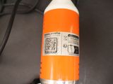 an orange and white bottle of soda on a table