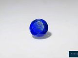 une pierre de saphir bleu sur une surface blanche