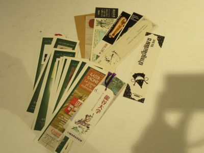 beaucoup de livres posés sur une table, avec l'ombre d'une chaise