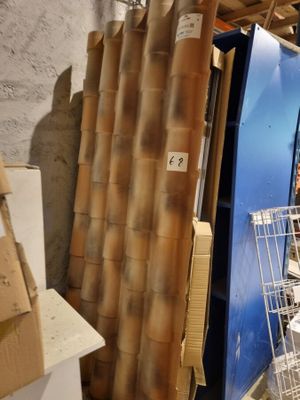un homme debout à côté d'un réfrigérateur dans une pièce remplie de cartons