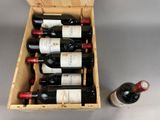 bottles of wine in a wooden box next to a bottle of wine