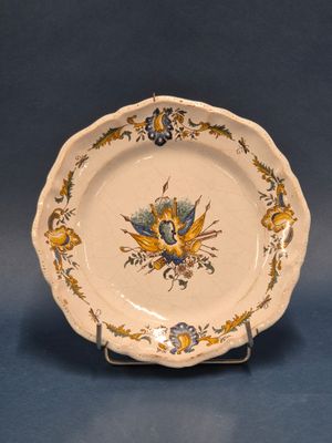 MOUSTIERS Assiette en faience à bords chantournés à décor de…