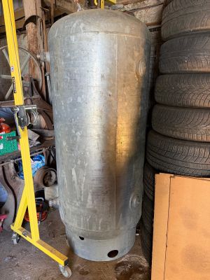 a large metal tank sitting next to a pile of tires
